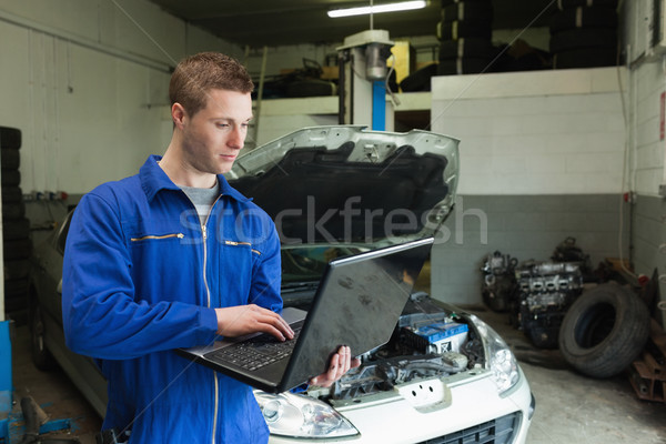 Mecanic folosind laptop garaj masculin maşină laptop Imagine de stoc © wavebreak_media