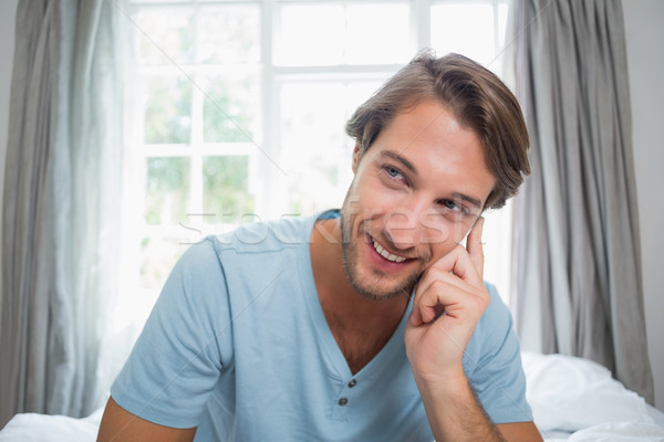 Handsome smiling man sitting on bed Stock photo © wavebreak_media