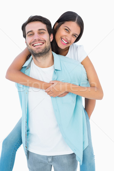Happy casual man giving pretty girlfriend piggy back Stock photo © wavebreak_media