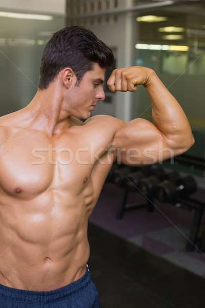 Stock photo: Muscular man flexing muscles in gym