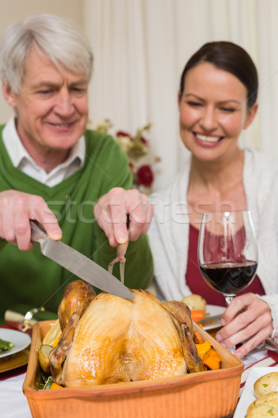 Grandfather carving chicken while woman drinking red wine Stock photo © wavebreak_media