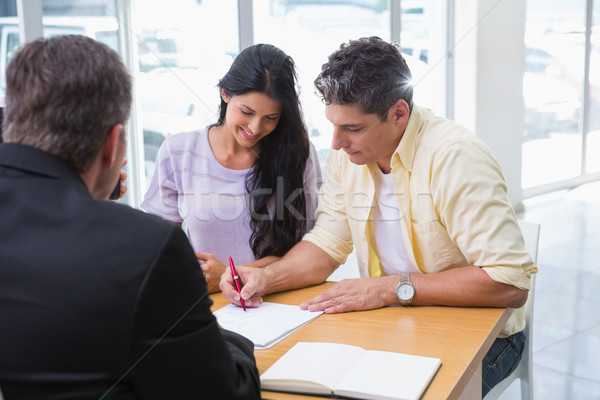 Stock photo: Smiling couple signing a contract