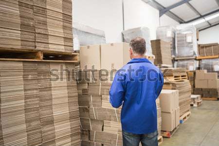 Stock photo: Smiling manager with arms crossed in warehouse