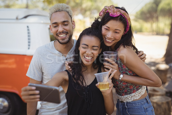 Happy woman with friends taking selfie from mobile phone Stock photo © wavebreak_media