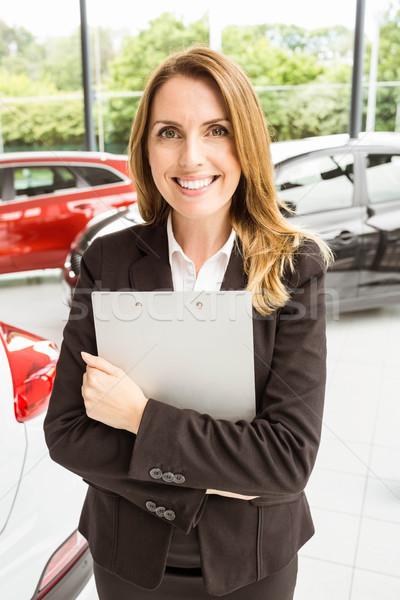 Smiling saleswoman holding document while looking at camera Stock photo © wavebreak_media