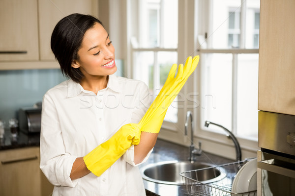 Smiling brunette wearing yellow gloves Stock photo © wavebreak_media