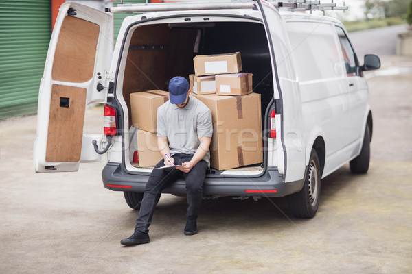 Delivery man writing on clipboard Stock photo © wavebreak_media