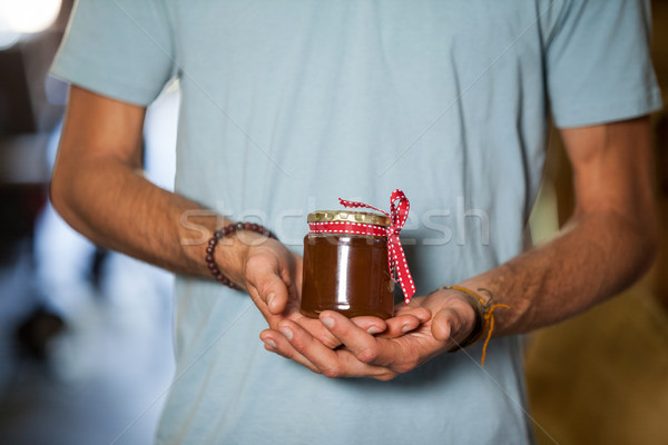Stock photo: Mid-section of man holding a jar of jam