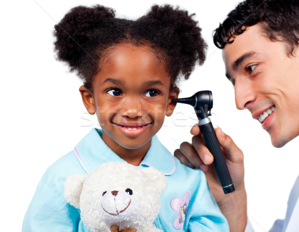 Stock photo: Adorable little girl attending medical check-up isolated on a white background
