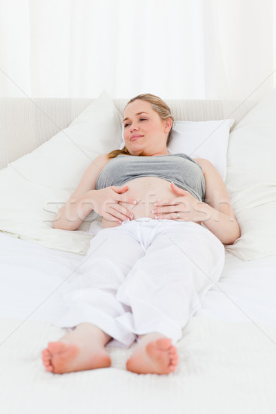 Beautiful woman with her hands on her belly at home Stock photo © wavebreak_media