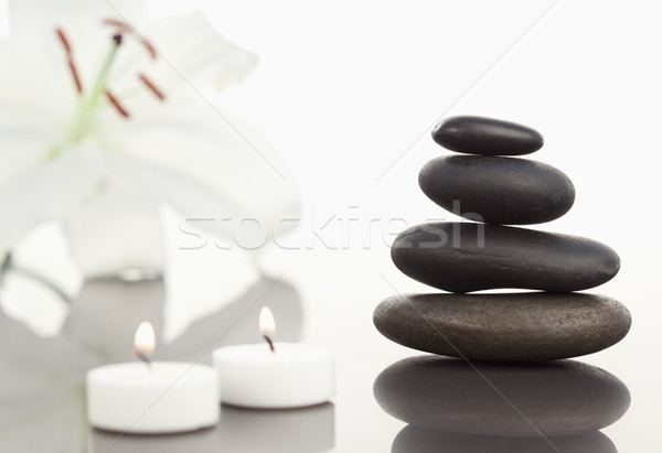 White orchid with lighted white candles and a black pebble stack the camera focus on the object Stock photo © wavebreak_media