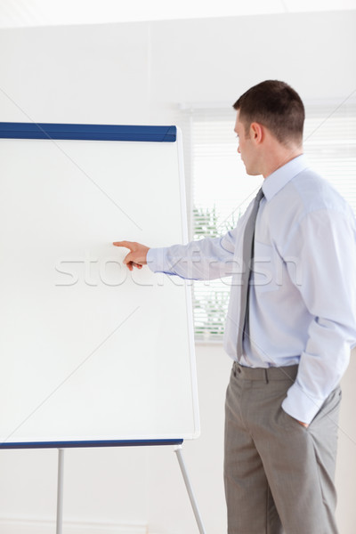 Confident businessman pointing at the middle of a flip chart Stock photo © wavebreak_media