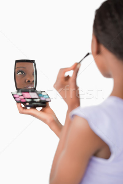 Close up of shadowing young woman while applying make-up against a white background Stock photo © wavebreak_media