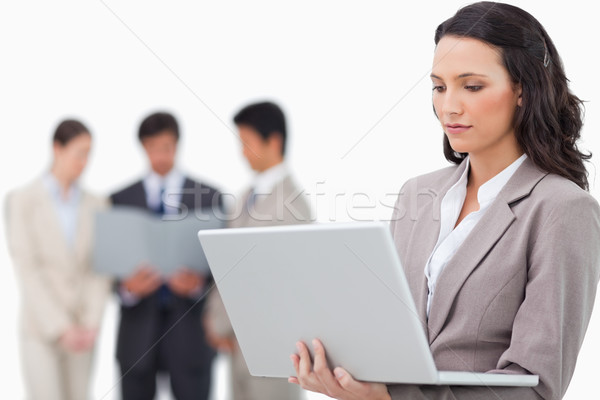 Saleswoman with notebook and colleagues behind her against a white background Stock photo © wavebreak_media