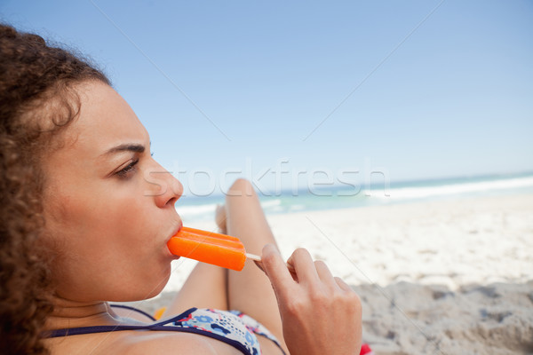 Jovem mulher atraente alimentação toalha de praia praia Foto stock © wavebreak_media
