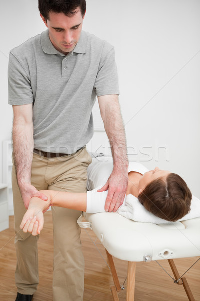 Serious practitioner holding the arm of a woman in a medical room Stock photo © wavebreak_media