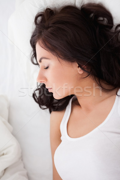 Stock photo: Calm woman lying on her bed while resting in her bright bedroom
