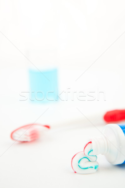 Red toothbrush next to a glass against white background Stock photo © wavebreak_media
