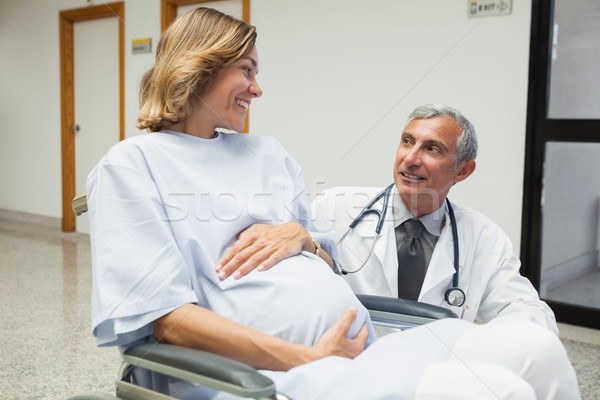 Doctor is talking to a pregnant woman in hospital corridor Stock photo © wavebreak_media