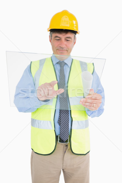 Man in vest and with helmet holding pane and pressing as a digital tablet while smiling Stock photo © wavebreak_media