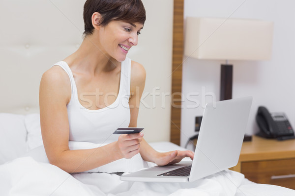 Femeie cumpărături on-line pat fericit camera de hotel Imagine de stoc © wavebreak_media