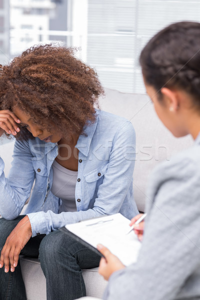 Stock photo: Upset woman crying on the sofa in therapy
