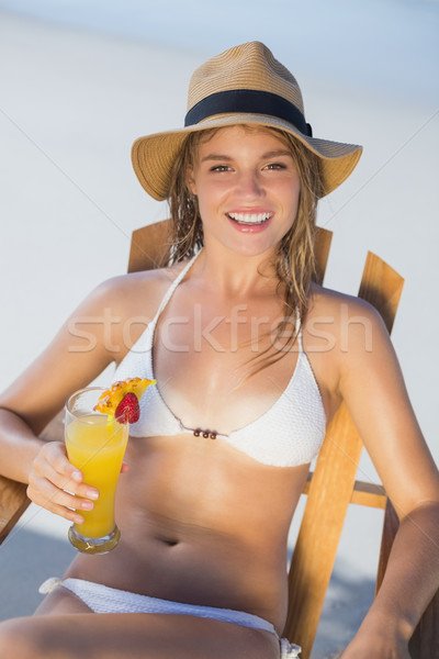 Pretty smiling blonde relaxing in deck chair on the beach with c Stock photo © wavebreak_media