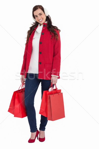 Happy brunette in winter clothes holding shopping bags Stock photo © wavebreak_media