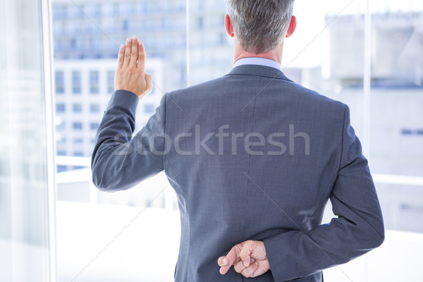 Businessman making a oath while crossing fingers  Stock photo © wavebreak_media