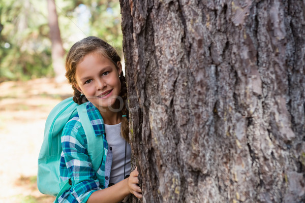 Smiling girl hiding behind the tree Stock photo © wavebreak_media
