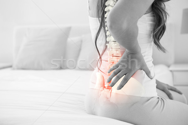 Compozit digitala sira spinarii femeie dureri de spate acasă pat Imagine de stoc © wavebreak_media