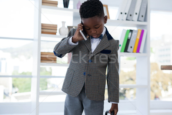 Businessman talking on mobile phone against shelf Stock photo © wavebreak_media