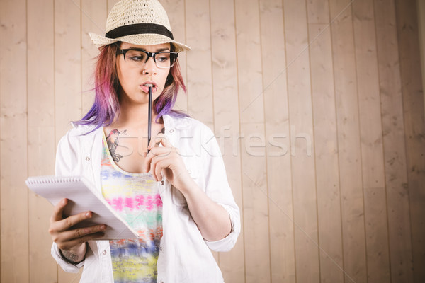 Stock photo: Thoughtful woman holding notepad and pen