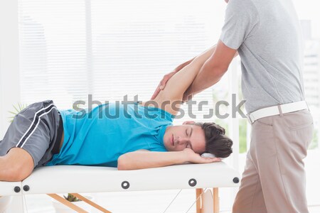 Physiotherapist assisting girl patient in performing stretching exercise from resistance band Stock photo © wavebreak_media