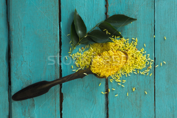 Raw organic yellow rice and curry leaves on wooden table Stock photo © wavebreak_media