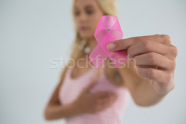 Stock photo: Close up of young female showing pink ribbon