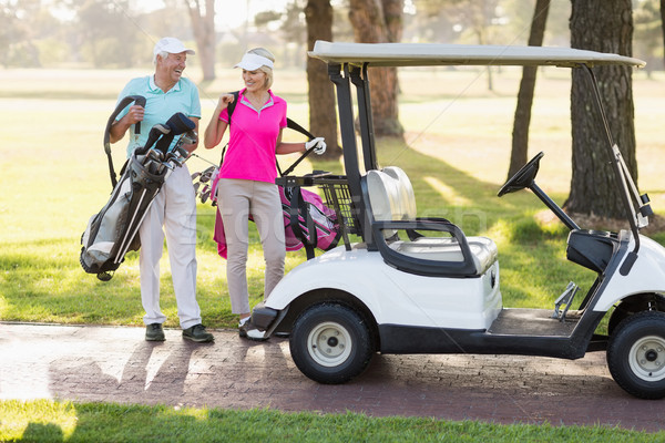 Happy mature golfer couple by golf buggy Stock photo © wavebreak_media