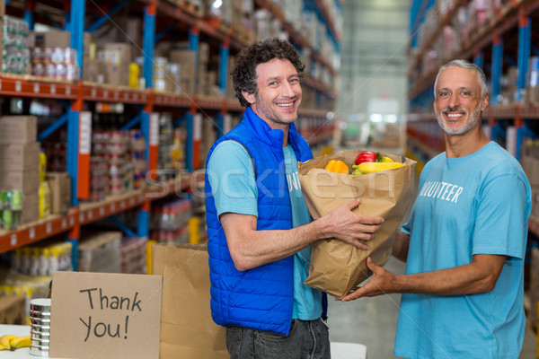 Stock photo: Portrait of happy volunteers holding a grocery bag 