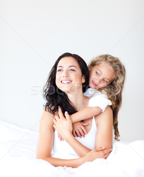 Smiling mother and daugther embracing on bed Stock photo © wavebreak_media