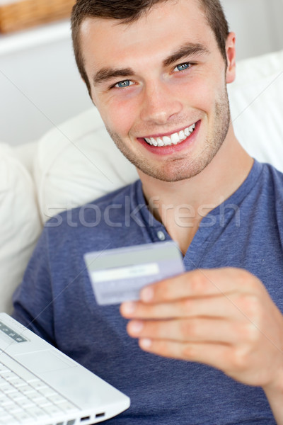 Close-up of a jolly man holding a card and a laptop Stock photo © wavebreak_media