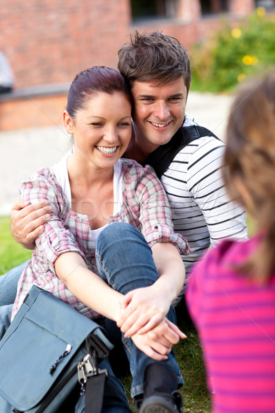 Young couple of students sitting on grass talking with a female friend Stock photo © wavebreak_media