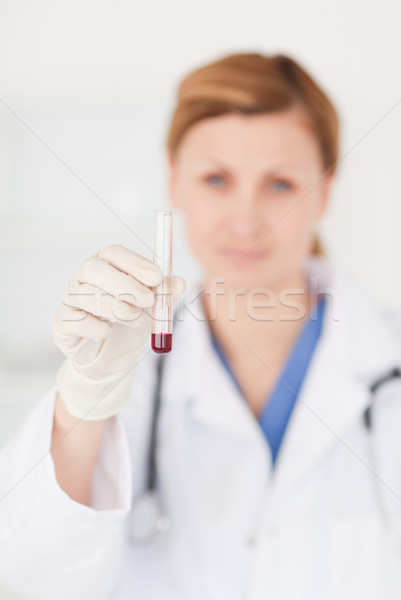Female scientist looking at the camera while holding a test tube in a lab Stock photo © wavebreak_media