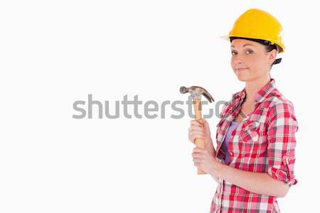 Stock photo: Beautiful woman holding a hammer while standing against a white background