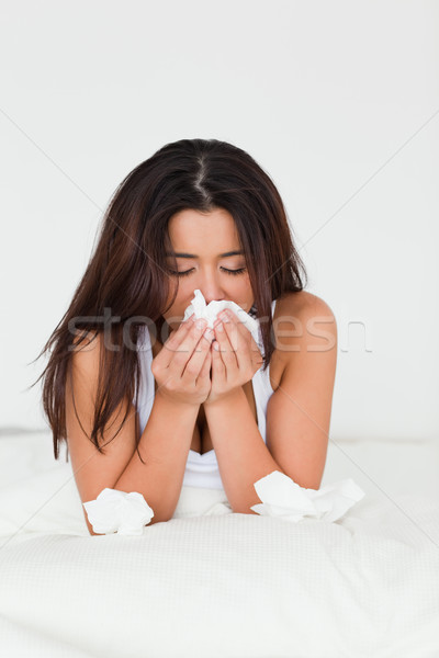 woman having a cold sitting in bed in bedroom Stock photo © wavebreak_media