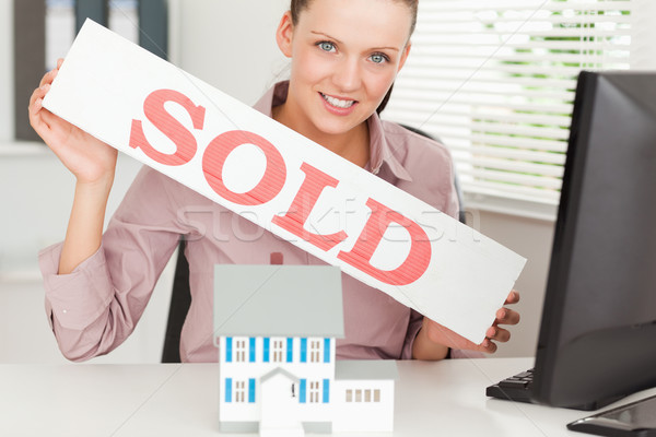 A businesswoman is showing a sold sign above a miniature house Stock photo © wavebreak_media