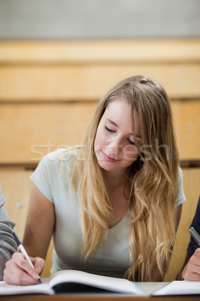 Portrait of a cute student writing on a notepad in an amphitheater Stock photo © wavebreak_media