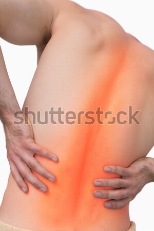 Young man experiencing back pain against a white background Stock photo © wavebreak_media