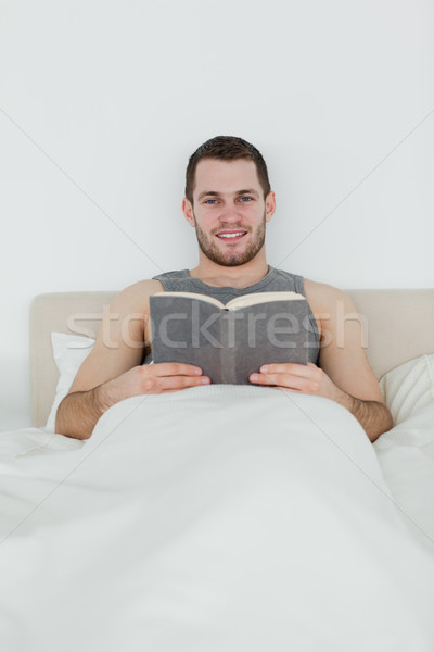 Stock photo: Portrait of a man reading a book in his bedroom