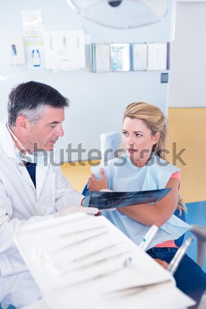 Stock photo: Young male doctor taking female patients blood pressure