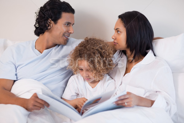 Jonge familie vergadering bed lezing boek Stockfoto © wavebreak_media